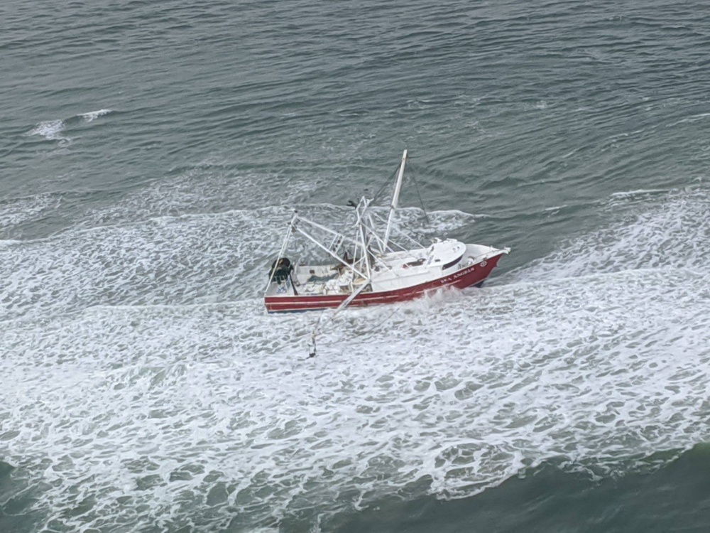 An aerial image of a fishing vessel listing to the side. 