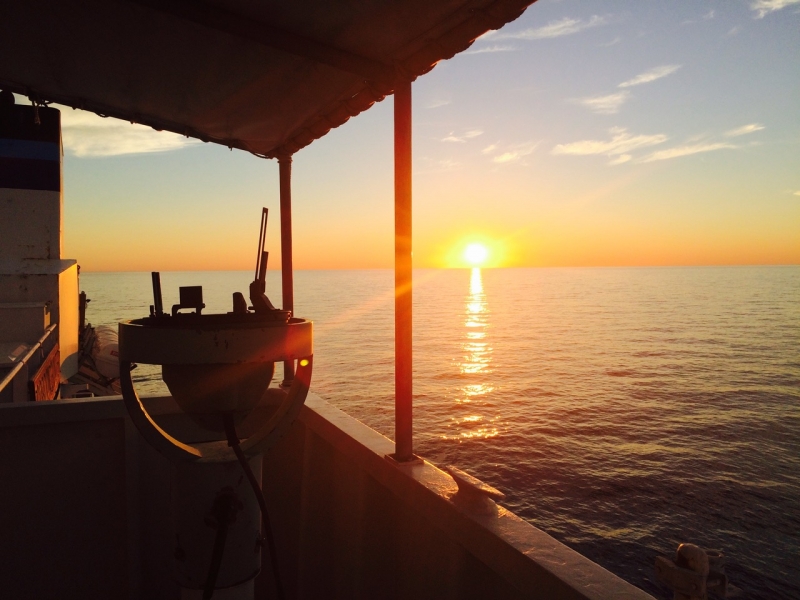 A sunrise as seen from a vessel on water.