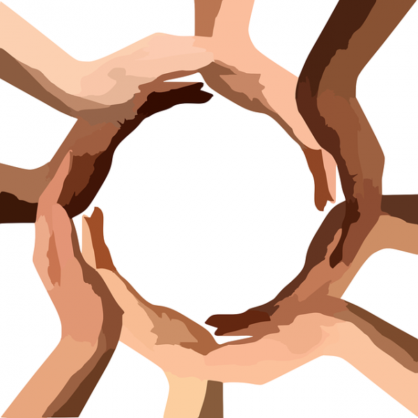 An image depicting a circle of hands of different colors creating a globe-like shape. 