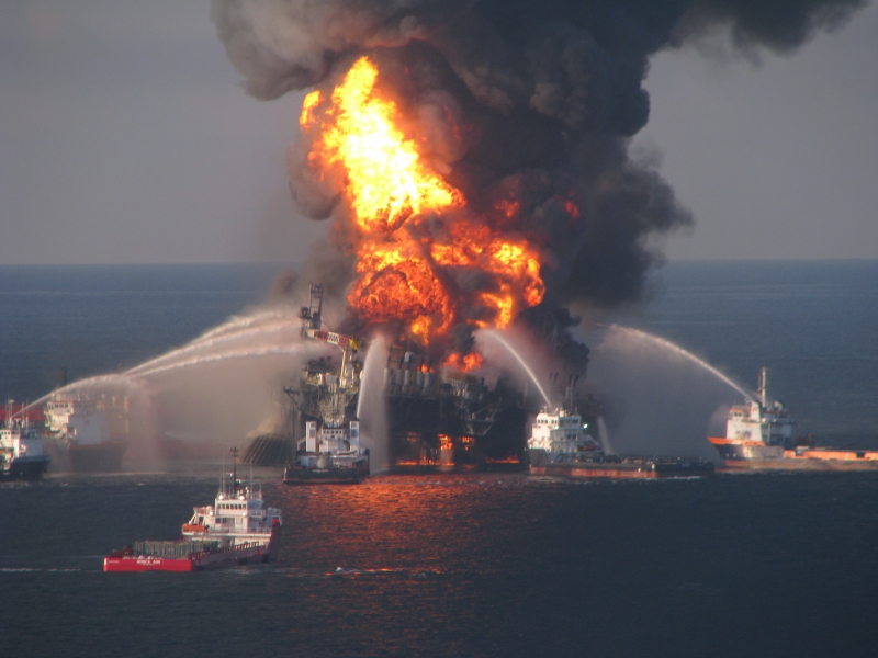 Several vessels pumping pressurized water on an oil platform on fire.