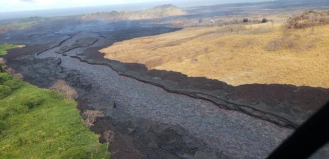 An aerial view of a river of black lava.