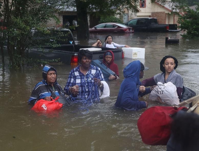 People moving through flood waters. 