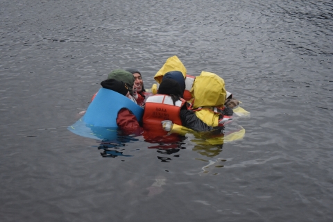 A group of people huddle together in water.