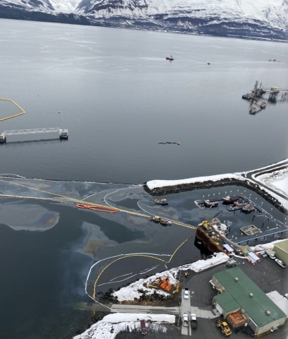An aerial view of oil in a marina with pollution boom around it.