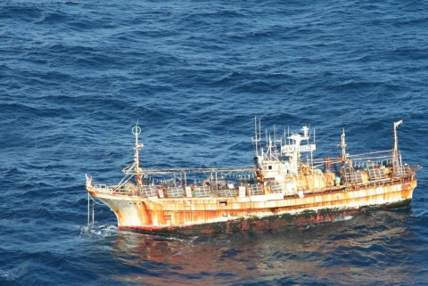 An old, rusted vessel adrift at sea.