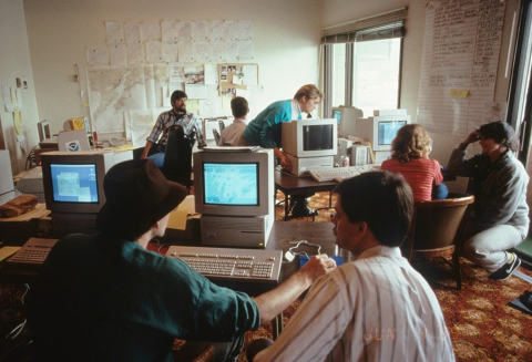 An old photo of people working on computers. 