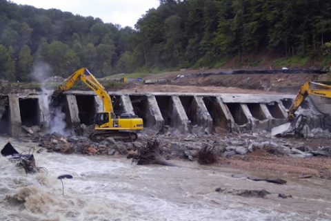 Excavation equipment moving rubble from a dam. 