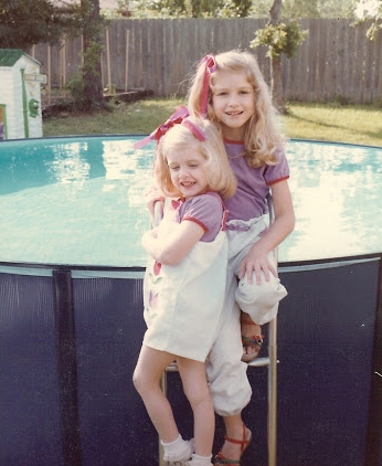 Two girls in front of a pool.