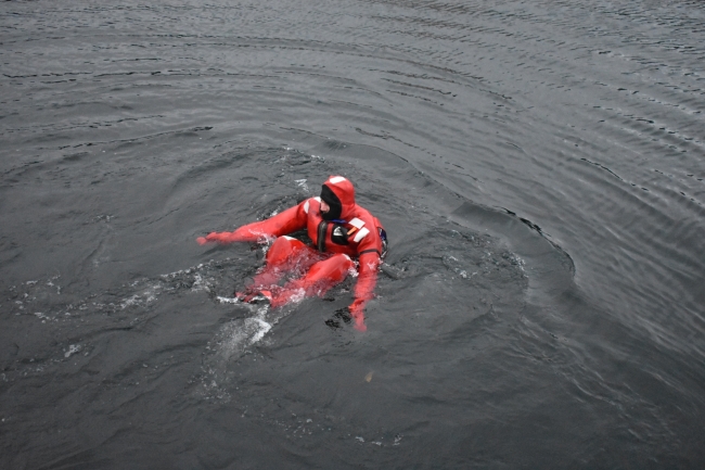 A person in a survival suit in the water.
