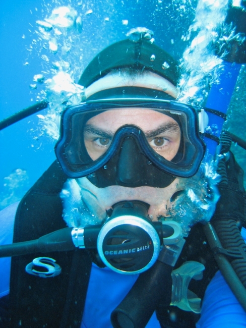 A portrait shot of a man in scuba gear underwater. 