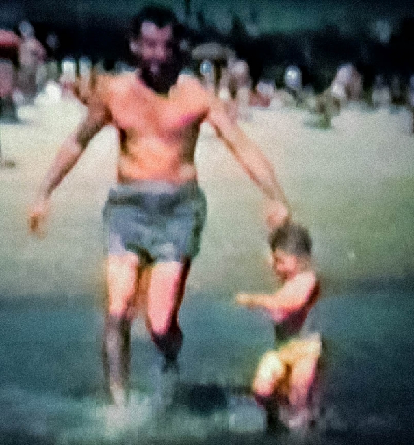 A man and a child on a beach.
