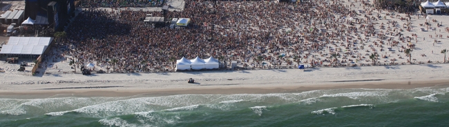 An aerial photo of a beach packed with people. 