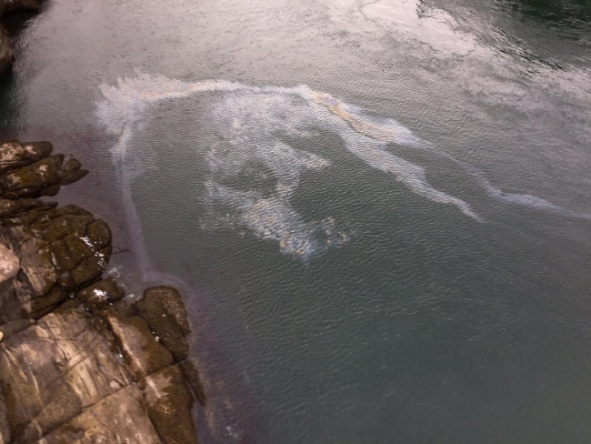An aerial image of an oil sheen in a body of water. 