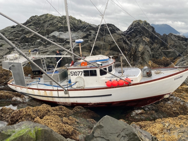 A vessel grounded on a rocky shore. 
