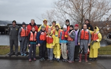 A group of people in life jackets pose for a photo. 