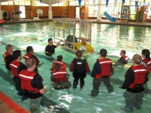 People in a pool wearing safety gear.