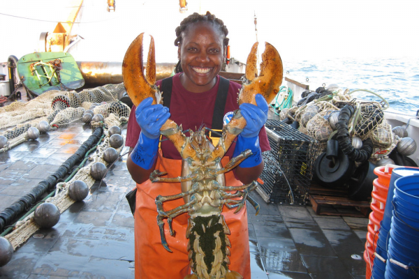 A person holding up a lobster.