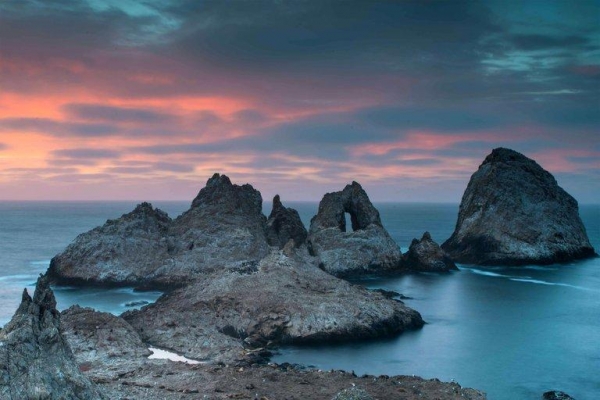 Rocky outcrops known as the "Devil's Teeth" in the water at sunset. 