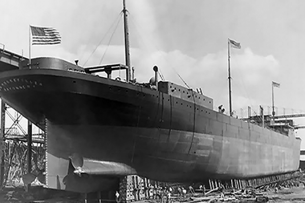 A black and white image of a vessel on land under construction.