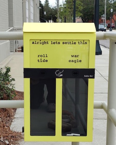 A yellow cigarette butt disposal bin installed on hand railing.
