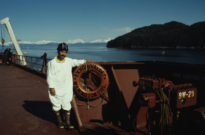 A man on a boat with a life ring reading "Exxon Valdez."