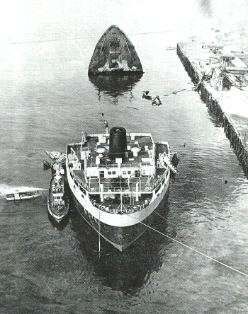 An old black and white photo of a vessel broken in half and partially submerged.