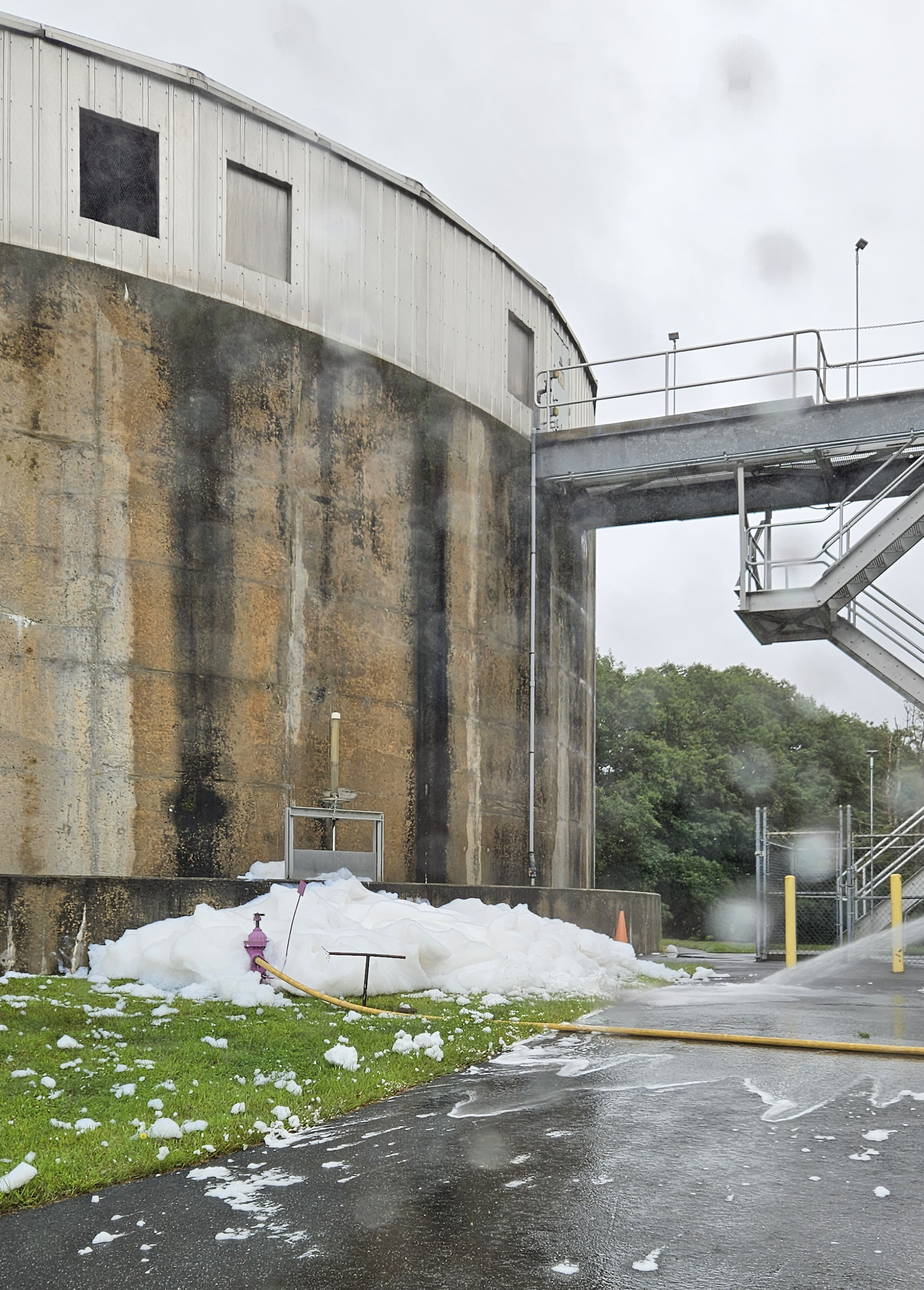 A foamy substance is observed next to a concrete facility.