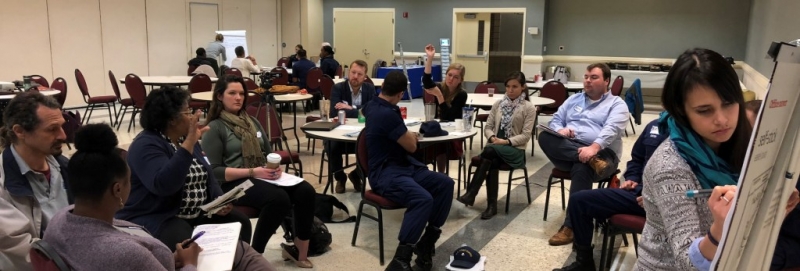 A group of people at conference tables in discussion.