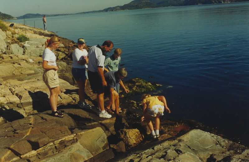A group of people on a rocky shoreline.