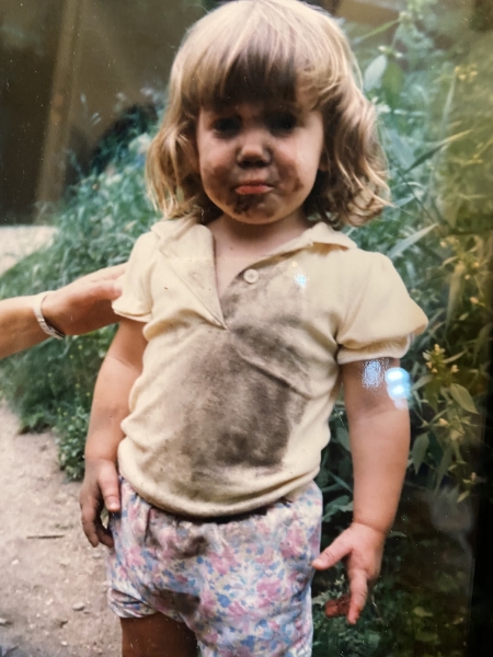A child covered in mud. 