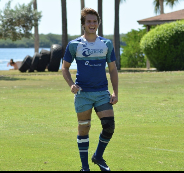 A person in an athletic uniform on a grassy field.