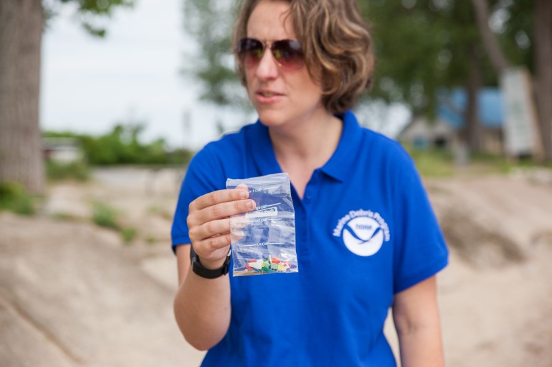 A woman holding a bag with plastics in it.