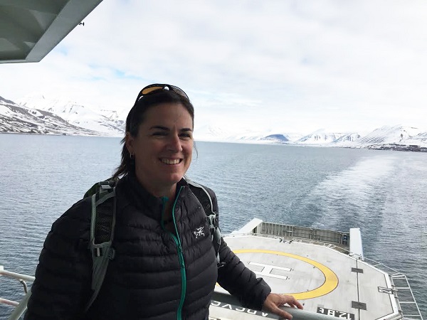 A profile photo of a woman with a watery arctic landscape in the background. 