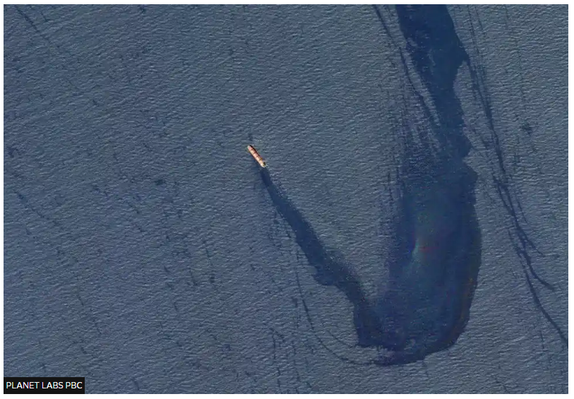 Satellite imagery of a vessel sustaining a missile strike in a large body of water.