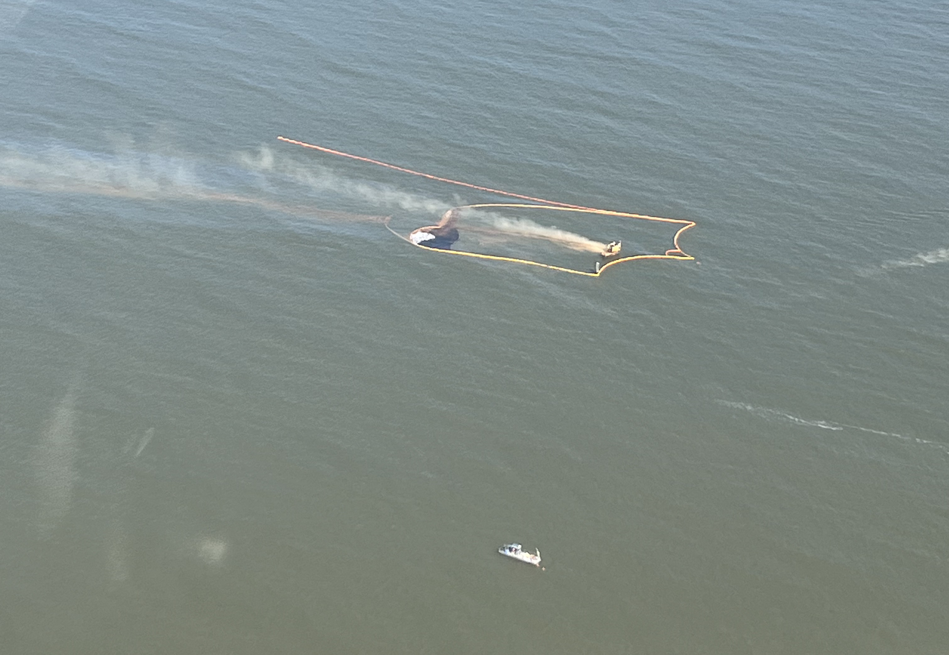 Overflight aerial image of spill boom containing oil in an open water environment.