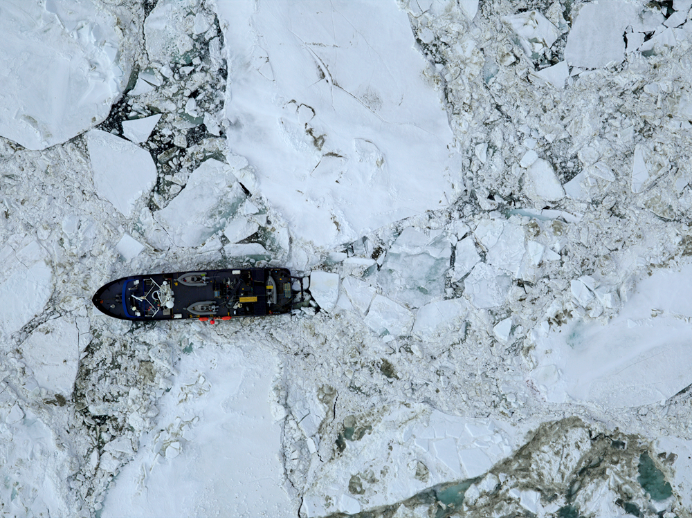 An aerial view of a research vessel stuck in sea ice.