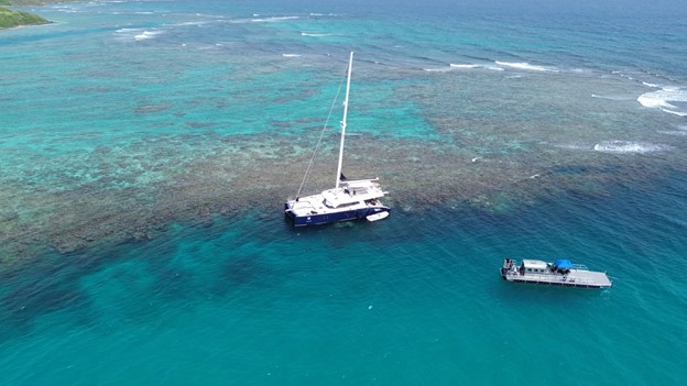 A sailing vessel aground on a coral reef in Puerto Rico with another vessel nearby.