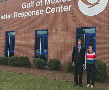 Two people standing in front of a building that reads "Gulf of Mexico Disaster Response Center." 