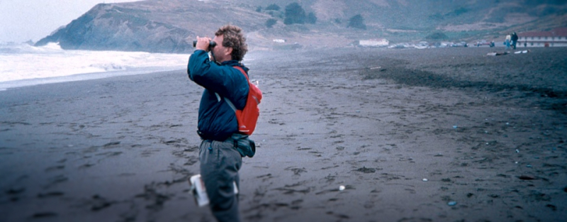 A person on a beach with binoculars. 