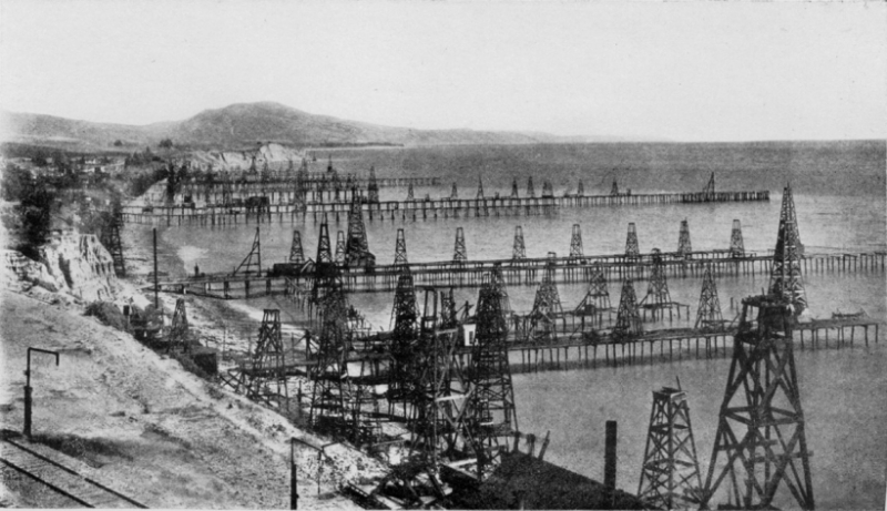 An old black and white photo of offshore oil wells. 