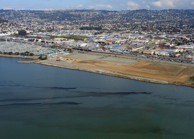 Oil in water with coastal development in the background. 