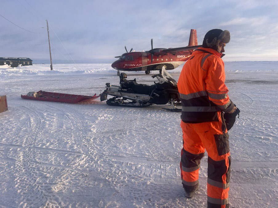 Aircraft, snowmachine with sled, and response team member at the February 2024 oil spill response at Kwigillingok. 