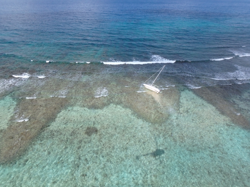 An aerial image of a vessel grounded in a reef.