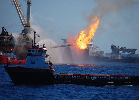 Several boats pump pressurized water at a fire on an oil platform.