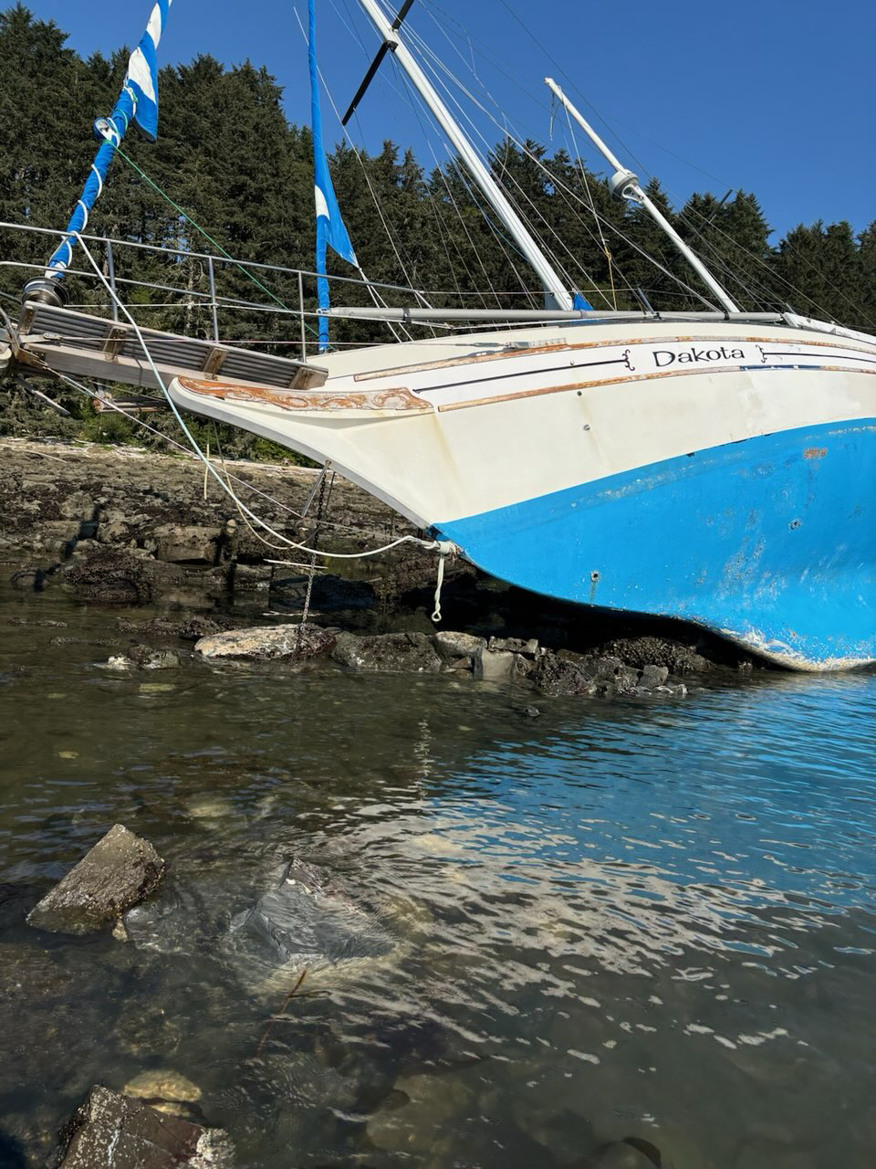 A sailboat aground on an island coastline.