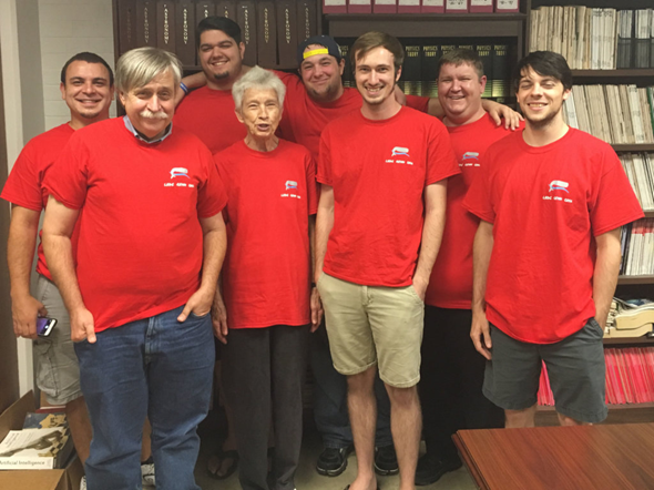 A group of people in red t-shirts posing for a photo.