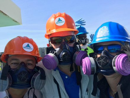 A three of people in respirators.