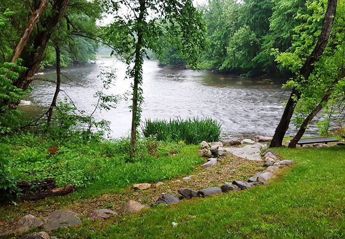 A rock-lined trail leading to a river. 