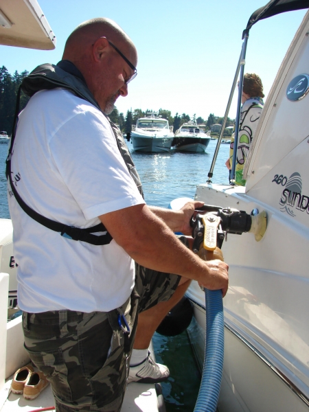 A man applying a pump to a boat. 