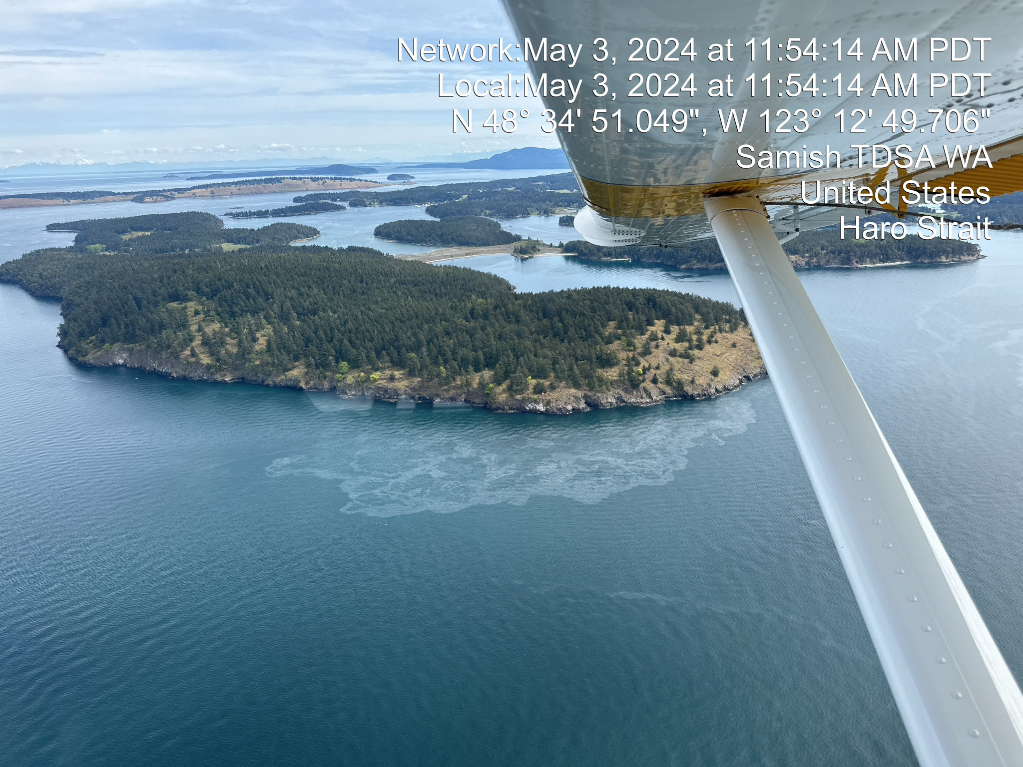 Aerial photo taken from a plane of an island with oil sheen observed off its coast.